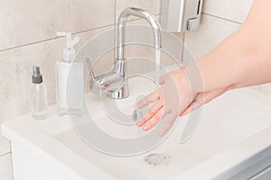 Closeup cropped profile photo lady wash arms sink stream hot water rub soap between fingers thirty seconds viral