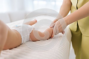 Closeup cropped shot of unrecognizable loving mom helping doing gymnastics exercise massaging to newborn son.