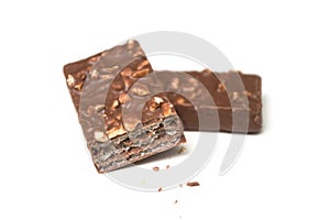 crunched chocolate bar with nuts on white background photo