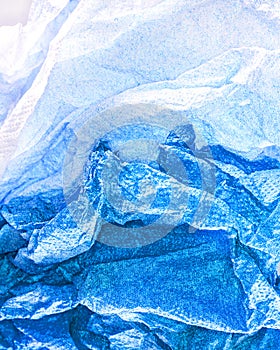 A closeup of crushed paper in blue and white .