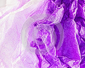 A closeup of crushed paper in violet and white .