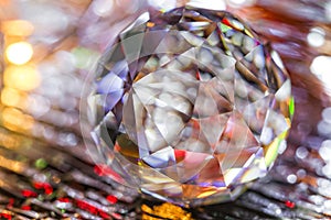 Closeup of crystal glass faceted ball on background of festive lights. Abstract festive, christmas or interior background.