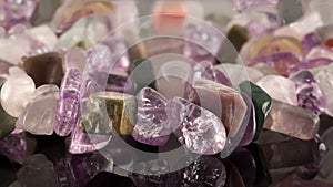 closeup crystals of amethyst, fluorite, jasper, carnelian and rose quartz on black table. Selective Focus