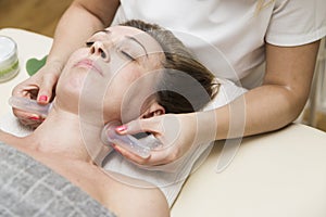 Cup applied to neck skin of a female patient as part of the traditional method of cupping therapy photo