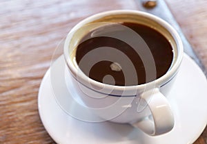 Cup of black coffee isolated on wooden table