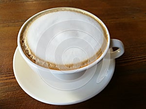 Closeup a cup of cappuccino coffee art on the wood table