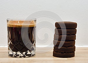 Closeup of a cup of coffee with 6 espresso shots and espresso pucks on the side