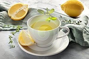 A closeup of a cup of green tea with lemons