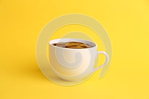Closeup of a cup of hot chocolate isolated on a yellow background