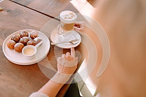Closeup cup with latte and donuts on a plate