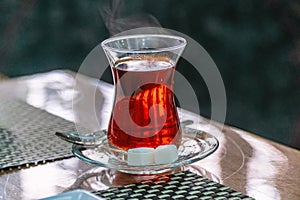 Closeup of cup of Turkish tea with sugar and spoon