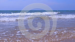 Closeup curly long foamy rolling in tube waves in stormy sea at sunny day.