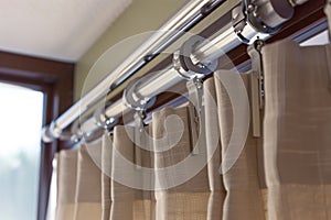 closeup of a curtain rod with a builtin track and sliders