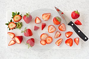 Closeup of Cut and Whole Strawberries on Cutting Board with Knife