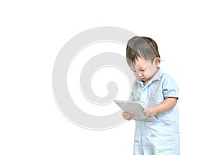 Closeup cute asian kid look at the tablet in his hand with serious face isolated on white background in work concept with copy spa