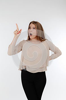 Closeup of cute blonde woman standing on white background. Young woman looking up