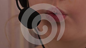 Closeup of a cute little girl in headphones singing in a microphone. 4K