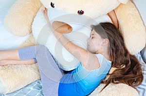 Closeup of cute sad little girl near the teddy bear. Varicella virus or Chickenpox bubble rash on child