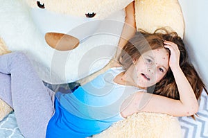 Closeup of cute sad little girl near the teddy bear. Varicella virus or Chickenpox bubble rash on child