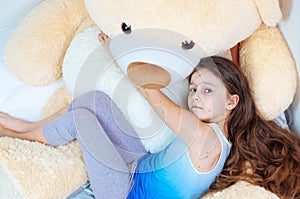 Closeup of cute sad little girl near the teddy bear. Varicella virus or Chickenpox bubble rash on child