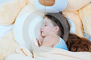 Closeup of cute sad little girl near the teddy bear. Varicella virus or Chickenpox bubble rash on child