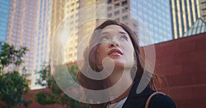 Closeup cute woman look back on city building. Portrait asian girl on sunlight.