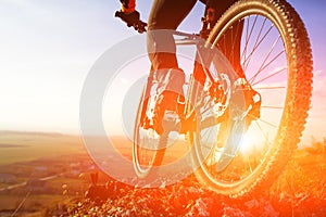 Closeup of cyclist man legs riding mountain bike on outdoor trail on hill