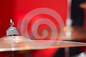 Closeup cymbal with drumkit partly visible blurry background, studio equipment concept