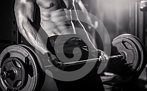 Sporty man lifts barbell in gym. Closeup deadlift barbells workout.Workout the gym. Athletic man with six pack, perfect