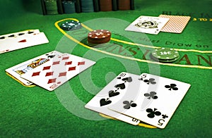 Closeup of dealt cards and stacks of chips on a Blackjack table in a casino