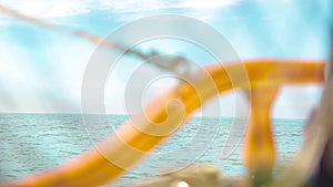 Closeup of the deck of a wooden antique Sail boat navigating in the ocean sunny day showing the wooden parts and