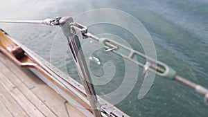 Closeup of the deck of a wooden antique Sail boat navigating in the ocean sunny day showing the wooden parts and