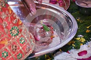 Closeup of decorated feet of an Indian bride while a traditional ritual performed during the wedding