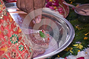 Closeup of decorated feet of an Indian bride while a traditional ritual performed during the wedding