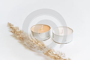 Closeup of decorative candles and golden wheats on a white background