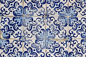 Closeup of decorative floral tiles. Blue traditional Portuguese ceramic tile pattern, azulejos. Beautiful shabby facade