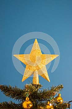 Closeup of a decorative ornament hanging from the Christmas tree covered with lights