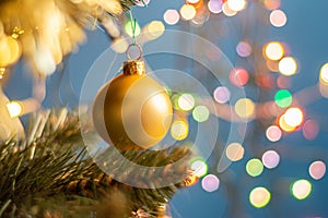 Closeup of a decorative ornament hanging from the Christmas tree covered with lights