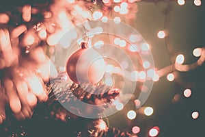 Closeup of a decorative ornament hanging from the Christmas tree covered with lights