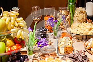 Closeup degustation premium cognac with snacks, fresh and dried fruits, pieces parmesan cheese, honeycombs, dark chocolate,