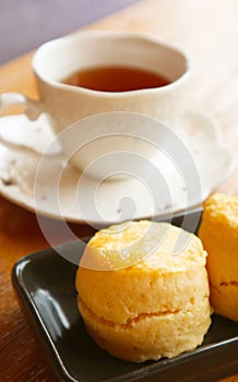 Closeup of a Delectable Scone with Tea Cup in the Backdrop