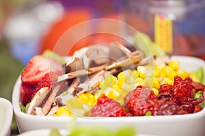 Closeup delicate fresh presentation of tuna salad in white bowl with colourful vegetables such as cole robbie, capsicum