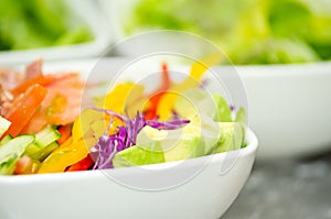 Closeup delicate fresh presentation of tuna salad in white bowl with colourful vegetables such as cole robbie, capsicum
