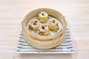 Closeup of delicious Chinese shumai dumplings on a xiaolong bamboo steaming basket