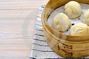 Closeup of delicious Chinese xiaolongbao steamed buns on a xiaolong bamboo steaming basket