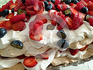 Closeup of delicious Finnish summer dessert called Brita cake made with meringue, fresh berries, whipped cream and sponge cake