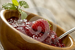 Closeup of delicious home made strawberry jam served in an elegant wooden bowl