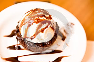 Closeup of a delicious icecream on top of a brownie with a chocolate sauce in the plate