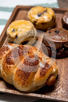 Closeup delicious sausage bread roll and fresh tasty scones on w