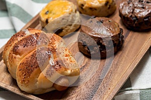 Closeup delicious sausage bread roll and fresh tasty scones on w